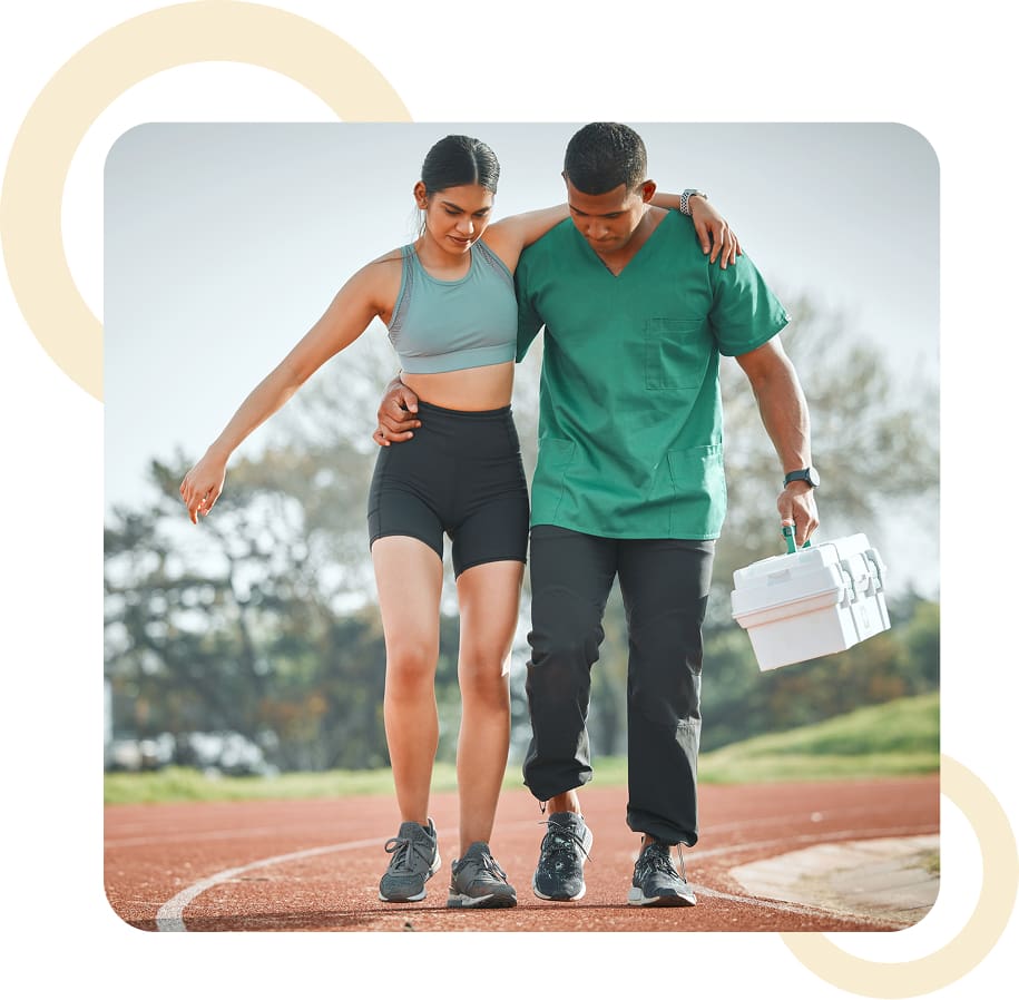 Athlete assisted by medic on track field.