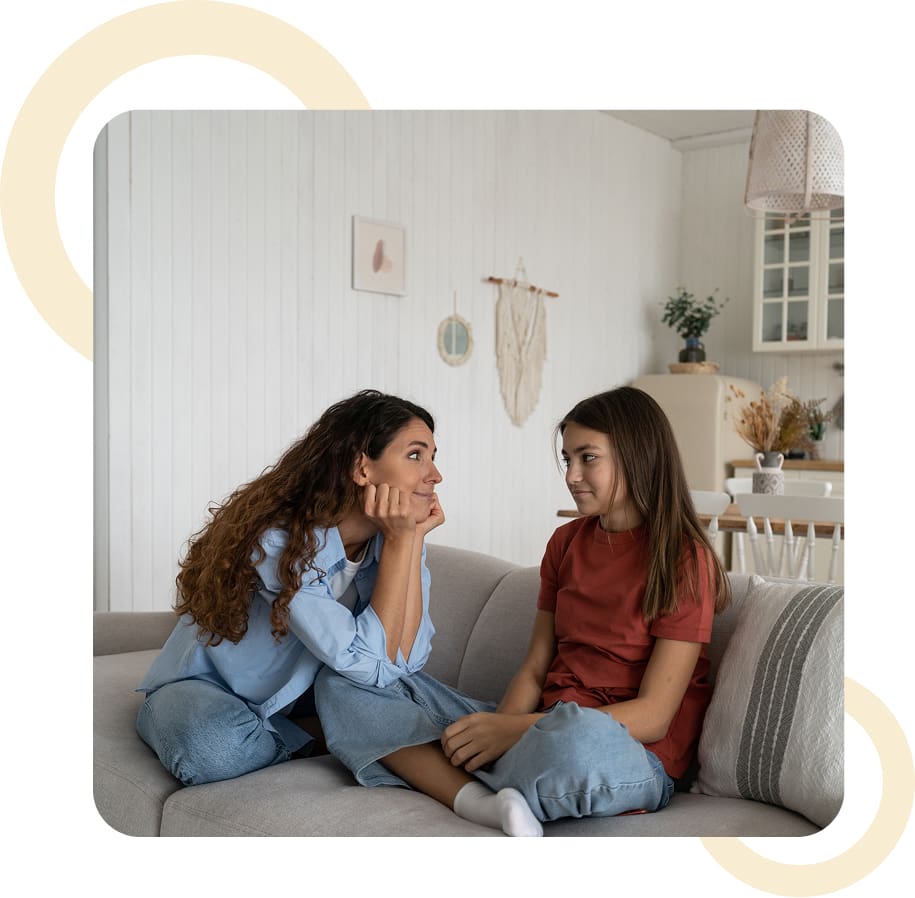 Woman and girl sitting on a couch.
