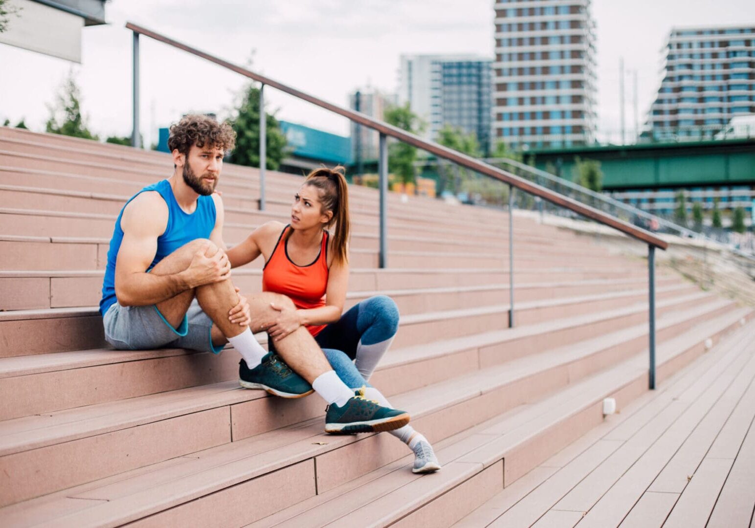 Man and woman resting on outdoor steps.