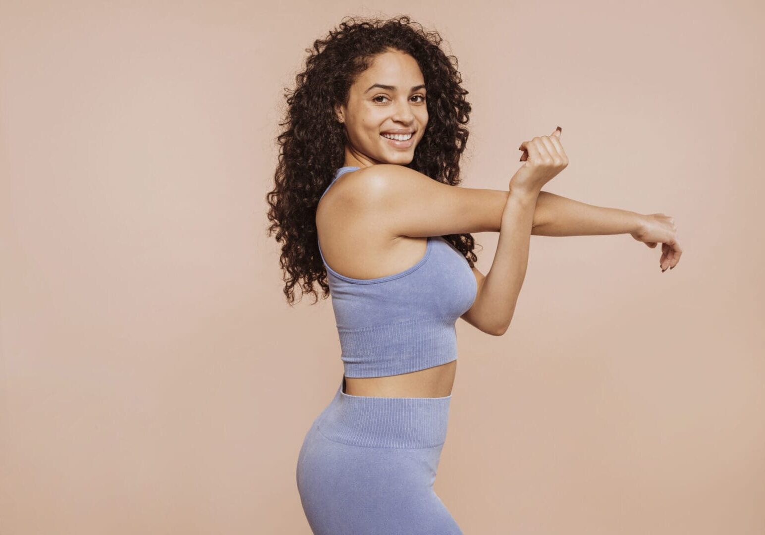 Woman stretching in blue workout attire.