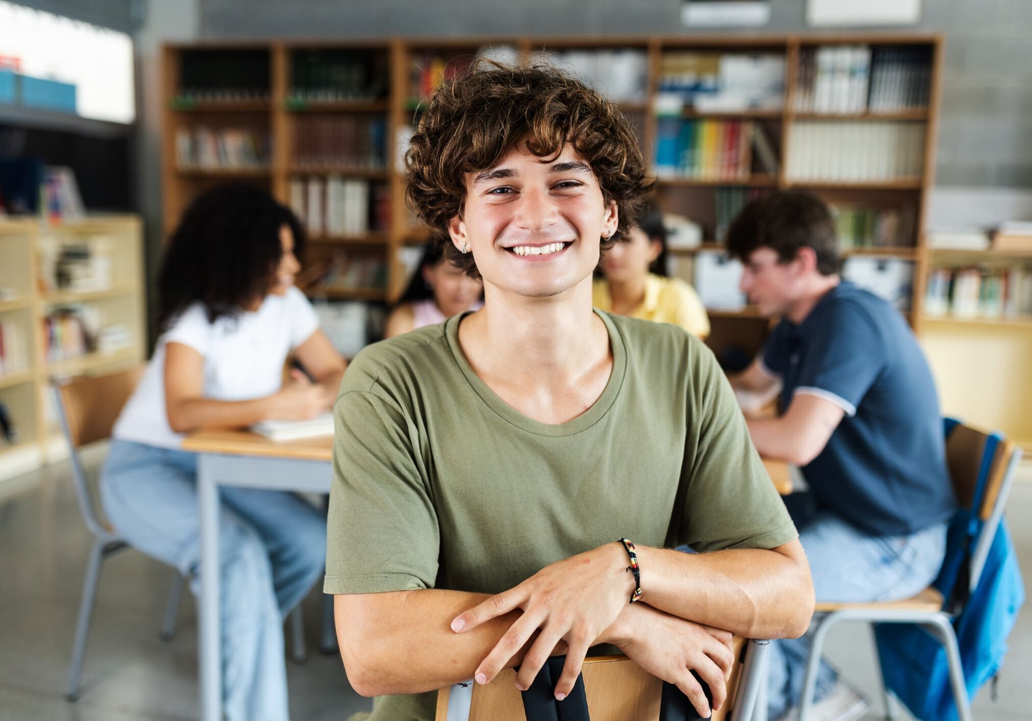 Smiling student in classroom with friends.