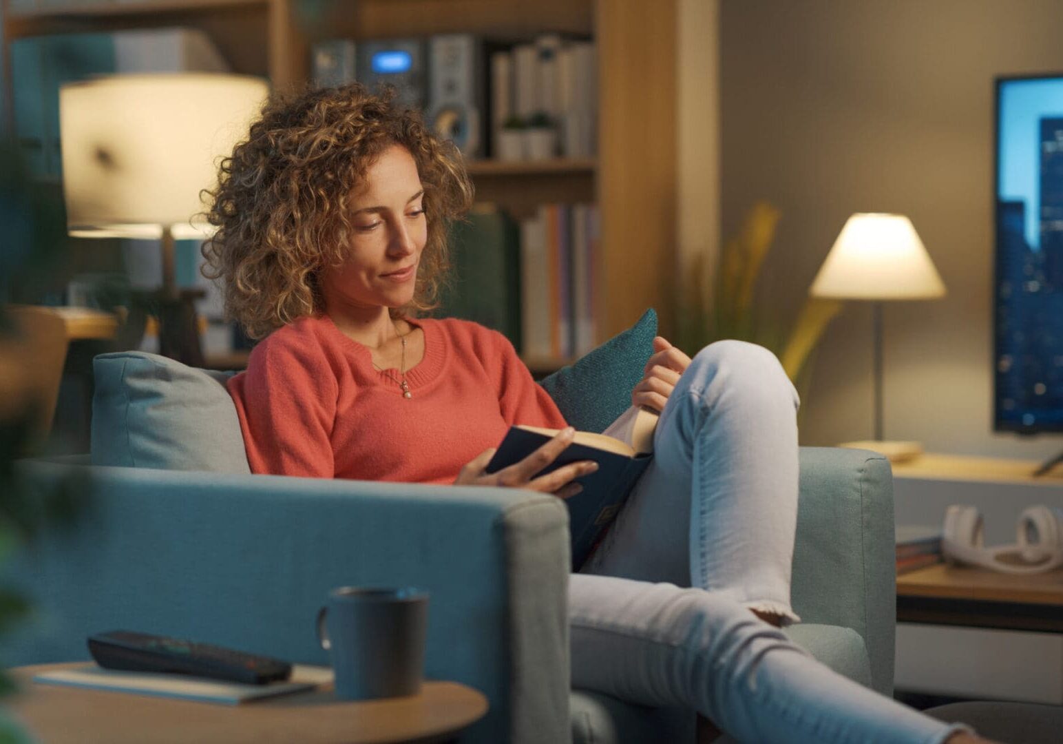 Woman reading on a sofa at home.