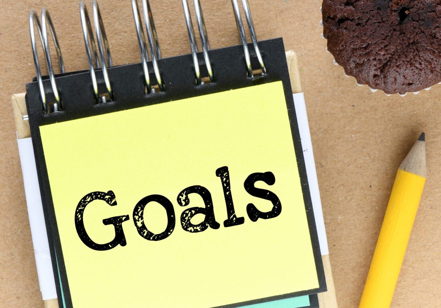 Sticky note with "Goals" beside pencil.