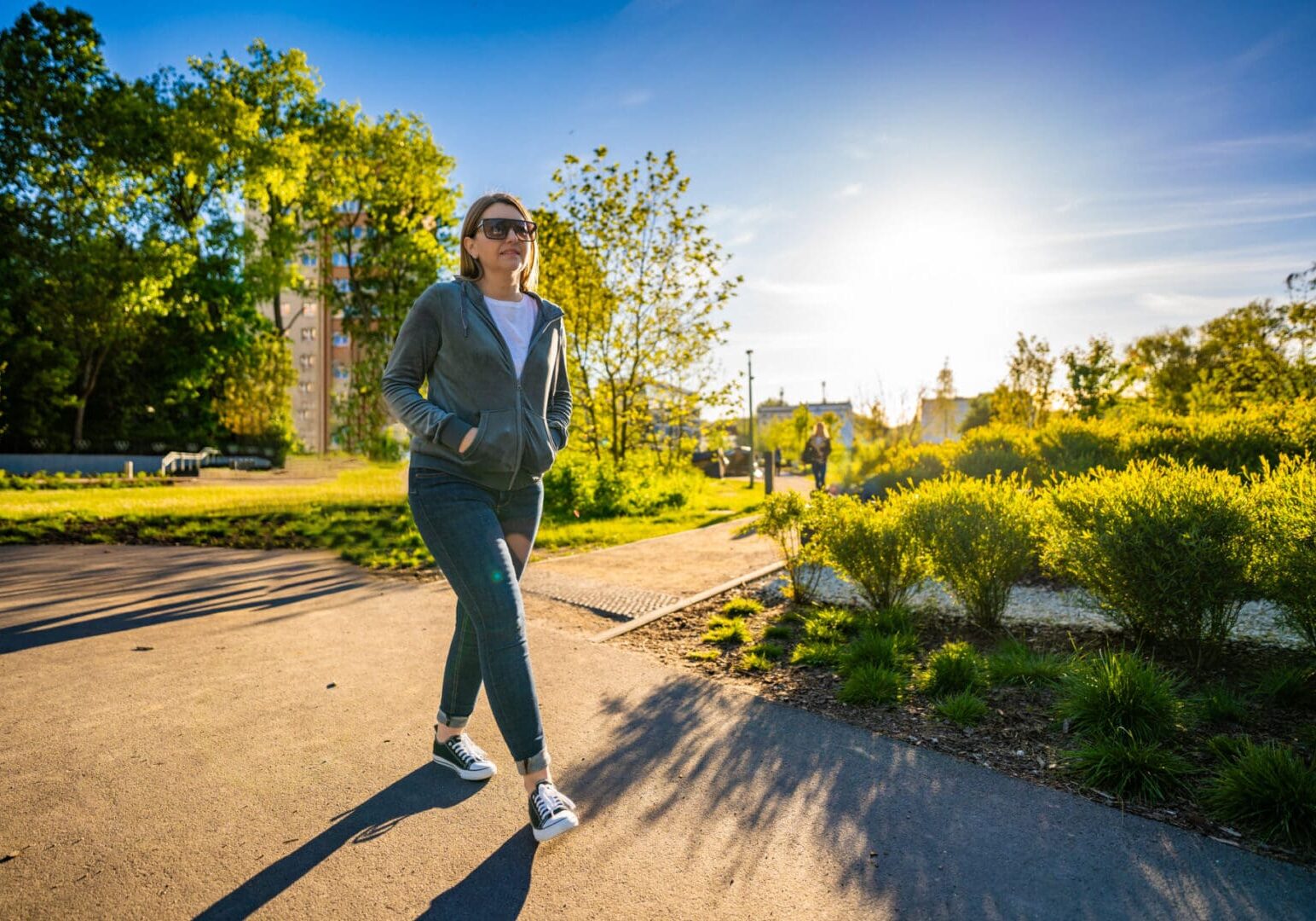 Person walking in park on sunny day.
