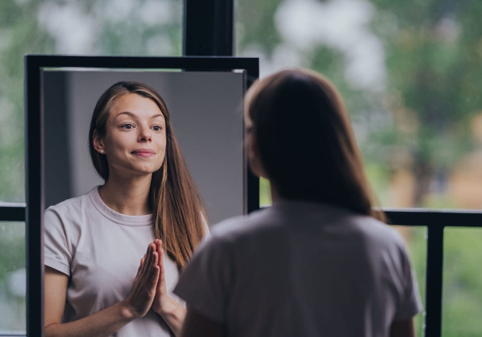 Woman looking at reflection in mirror.