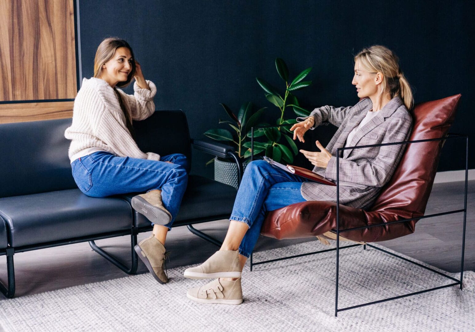 Two women having a casual conversation indoors.